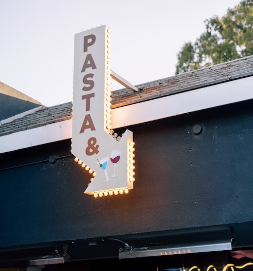 Image of pasta and wine sign outside of Jame